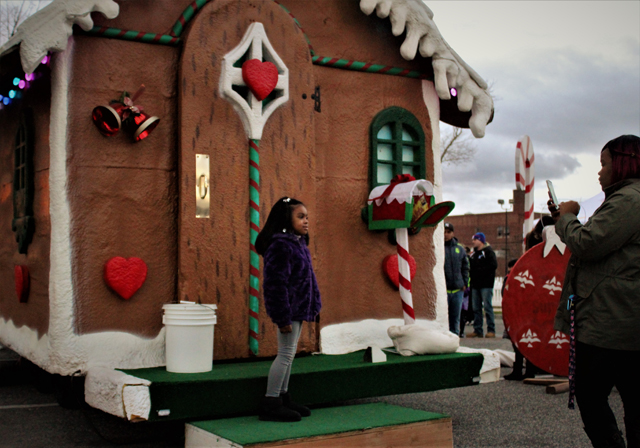 A young girl poses for a photo in front of Santa’s Gingerbread House . (Credit: Elizabeth Wagner)