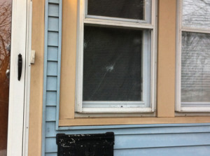 CARRIE MILLER PHOTO | Bullet holes in the window of an East Avenue home Tuesday morning.