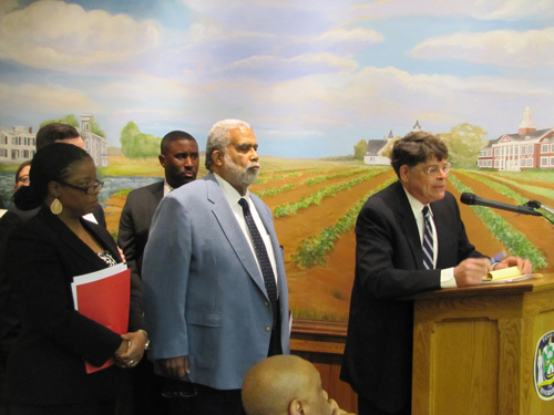 Rev. Charles Coverdale, center, and Assistant Pastor Cynthia Liggon line up behind attorney Guy Germano at the podium Tuesday.