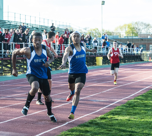 Riverhead's Marcus Moore hands the baton to Davion Porter for the final leg of the 4 x 400 relay Tuesday. (Credit: Robert O'Rourk)
