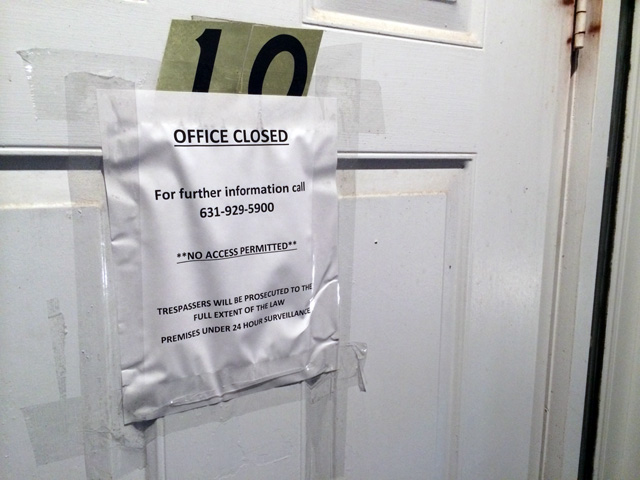 Ten of these signs are posted on the doors and windows of Dr. Robert Bernard's longtime practice in Wading River. (Credit: Grant Parpan)