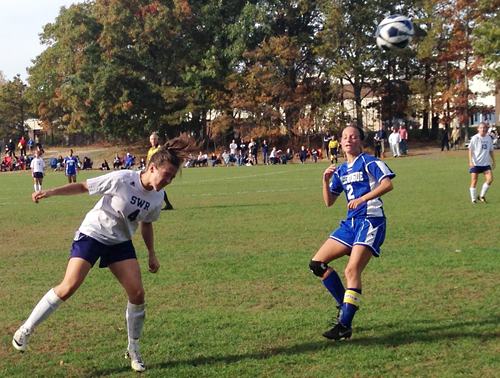 Shoreham-Wading River senior Emily Blunnie heads the ball in Tuesday's playoff win over Comsewogue. Blunnie scored once in the win. (Credit: Joe Werkmeister)