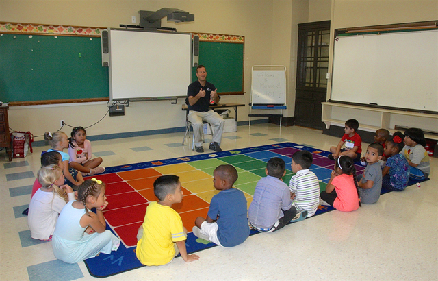 Music teacher Roy Buccola gives his first class of kindrgarten students a couble thumbs up. This is his new classroom with plenty of room to move and dance.