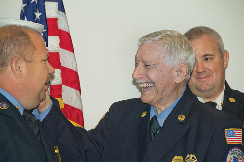 Michael DeNicolo is Flanders Fire Department's first 50-year member. Mr. DeNicolo thanks Commissioner Rob Merker (left) last week while Chief Joe Petit looks on.