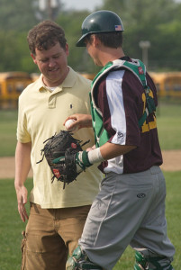 GARRET MEADE PHOTO | The Hamptons Collegiate Baseball League president, Brett Mauser, is handed the ball by Riverhead Tomcats catcher Jason Gordon after throwing the ceremonial first pitch.