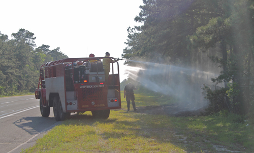 PAUL SQUIRE PHOTO | Riverhead firefighters douse the brush fires from a brush truck Thursday afternoon.