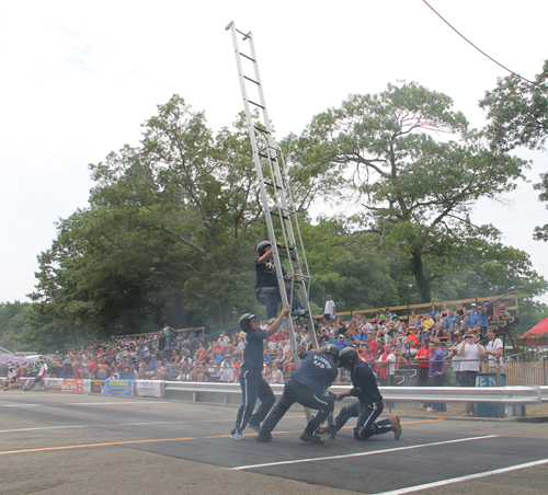 PAUL SQUIRE PHOTO | Riverhead firefighters compete in the 3-man ladder event Saturday afternoon.