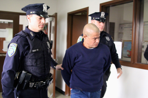 JENNIFER GUSTAVSON PHOTO | Joseph Plummer is led into Riverhead Town Justice Court before his arraignment in January. He has since pleaded guilty to hitting a man with his car and fleeing the scene.