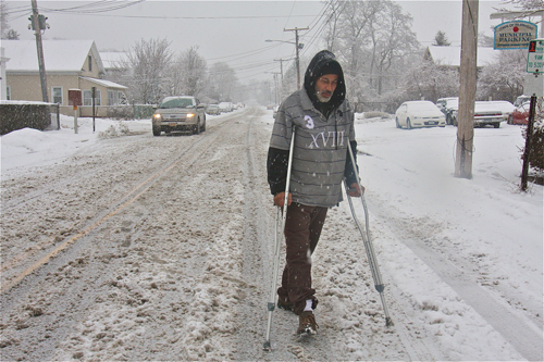 BARBARAELLEN KOCH PHOTO | Angel Almenis makes his way down Hamilton Avenue on crutches still recuperating from a broken ankle after he was hit by a car four months ago. He was headed to the Polish Town Corner Grocery and Deli to get coffee and breakfast.