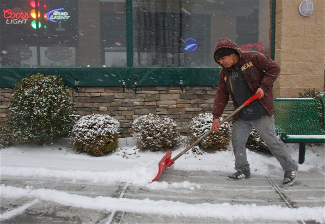 Luis Lopez cleaning off the sidewalk in front of Joe's Garage and Grill. (Credit: Barbaraellen Koch)