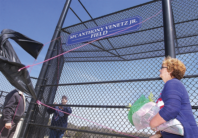 Marion Venetz (right) helping to unveil the sign naming field two at Veteran's Memorial Park in Calverton after her son during Little League opening day ceremonies lin 2013. (Credit: Barbaraellen Koch, file)