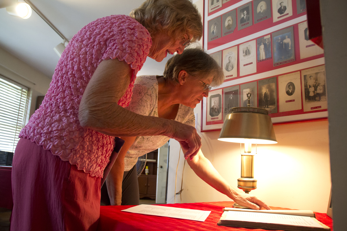 Volunteers Irene Pendzick (left) and Maria Tobiasz look over a list of Polish Town immigrants at the recreated exhibit Monday afternoon. (Credit: Paul Squire)