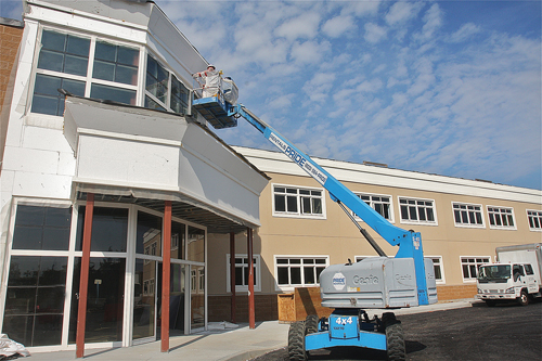 Mario Anthony and Anthony Esbarr of Atlas Stucco work on the front entrance to the charter school's new building Tuesday. (Credit: Barbaraellen Koch)
