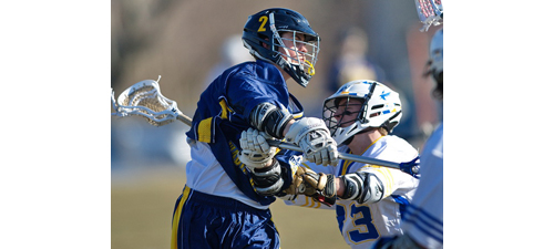 Shoreham-Wading River's Alex Makoske unleashing a shot in the face of defensive pressure from Mattituck/Greenport/Southold's Tim Schmidt. (Credit: Garret Meade)