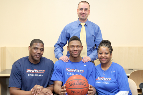 Brandon Tolliver is pictured with his mother and father Shanneikqua and Bill Tolliver with Varsity Basketball Coach John Rossetti.