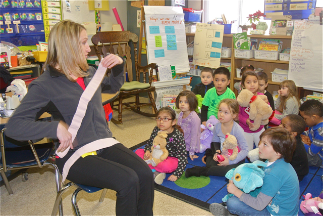 Ms. Ladowski shows the students how to properly buckle up a car seatbelt.