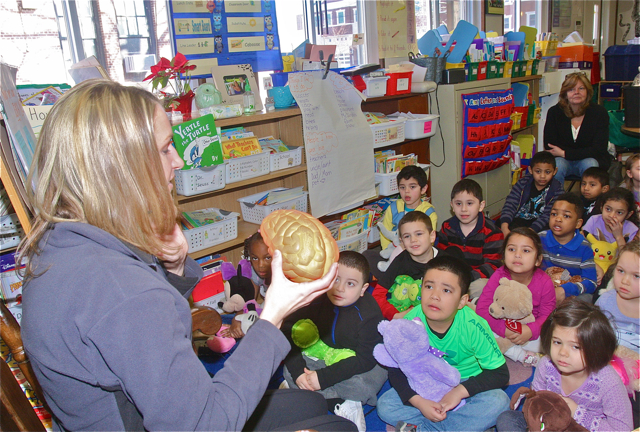 Kristi Ladowski tells the children about the importance of proper fitting helmets when biking, riding scooters and playing sports.
