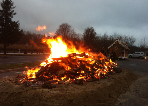 TIM GANNON PHOTO | Thousands of pieces of wood keep the annual bonfire roaring in downtown Riverhead. TIM GANNON PHOTO | Thousands of pieces of wood keep the annual bonfire roaring in downtown Riverhead.