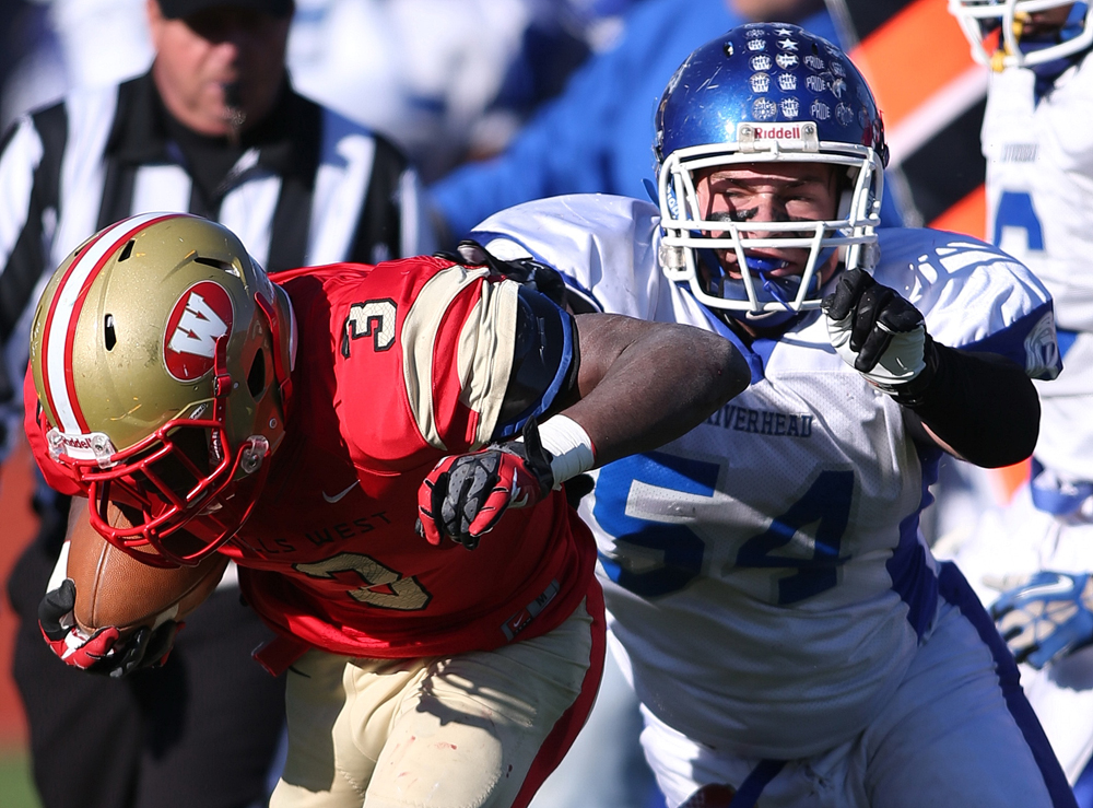 Riverhead's Raheem Brown pursuing Hills West quarterback Jacob Robinson in Saturday's loss in Dix Hills. (Credit: Garrett Meade)