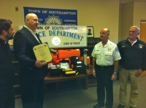 TIM GANNON PHOTO | CAPTION: The Hamptons Health Society donated more than $30,000 worth of emergency life support equipment to the Southampton Town Police Monday. From left are Father Constantine of the Greek Orthodox Christian Church of the Hamptons, which gave money toward the purchase, Dr. Peter Michalos of Hamptons Health Society, Southampton Police Chief Robert Pearce, and Jimmy Mack of the Robins Island Foundation, which also raised money for the purchase.