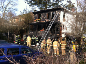 MICHAEL WHITE PHOTO | Firefighters douse the remnants of a Riverside Drive fire on Wednesday.