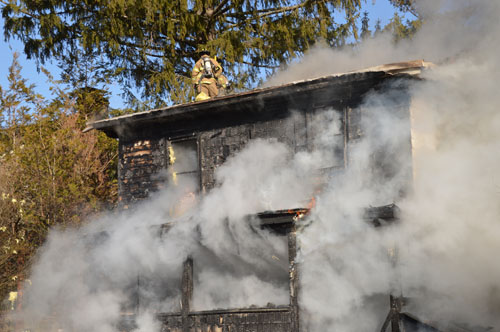TOM LAMBUI PHOTO/LIHOTSHOTS.COM | Firefighters battle a Riverside Drive house fire from the roof Wednesday.