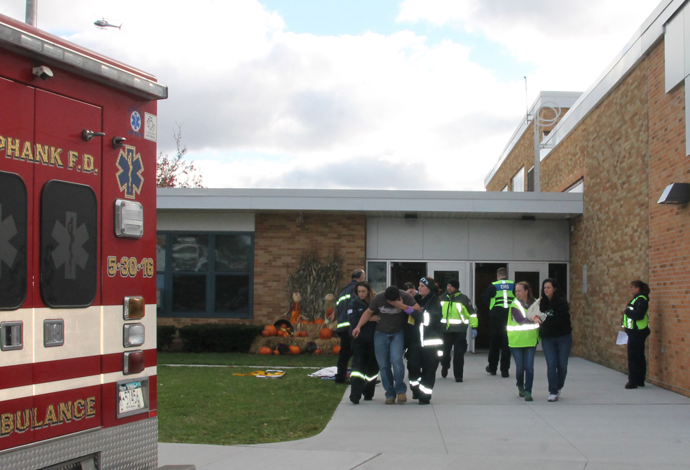 A shooting 'victim' is escorted from Riley Avenue Elementary School during Saturday morning's active shooter drill. (Credit: Michael White)