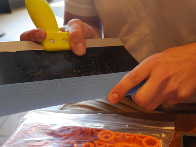 Sam Notaro shows off his most recent product, simpliseam, an add-on to a spackle blade designed to make the spackle completely smooth when dry. (Credit: Krysten Massa, August 2016)