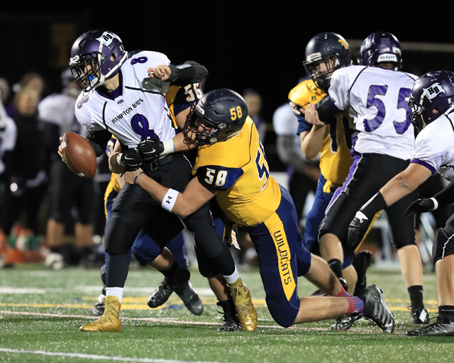 Dean Stalzer (No. 58) and Logan Snyder (No. 56) sack Hampton Bays quarterback Nico Antieri Friday night. (Credit: Daniel De Mato)