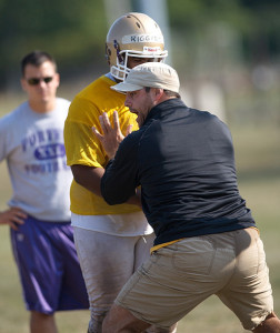 GARRET MEADE PHOTO | Assistant coach Chris Robinson working with Willie Riggins while assistant coach Mike Miller watches in the background.