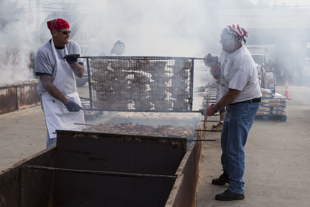 Mike Finnigan, left, and Teddy Behr flip the chicken. (Credit: Katharine Schroeder)
