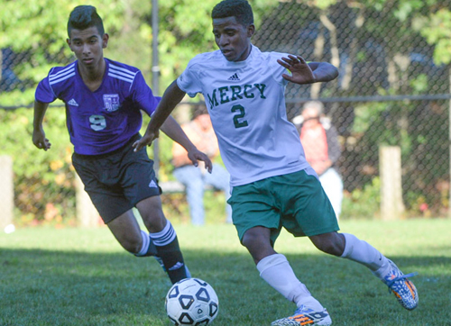 Bishop McGann-Mercy's Bereket Watts turns the ball upfield against Hampton Bays' Loaiza Cristian. (Credit: Robert O'Rourk)