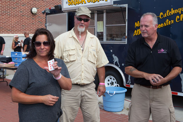 Lori Kazic, left, and Andrew Vogeney, center tied for second best poker hand, then drew a card to decide the winner. They both drew a 9. Andrew ended up winning and donating his prize back to Kait's Angels. (Credit: Katharine Schroeder)