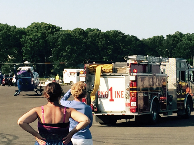 Onlookers watch as Mark Coen is brought to a police helicopter in Greenport Saturday. (Credit: Sonja Reinholt-Derr)
