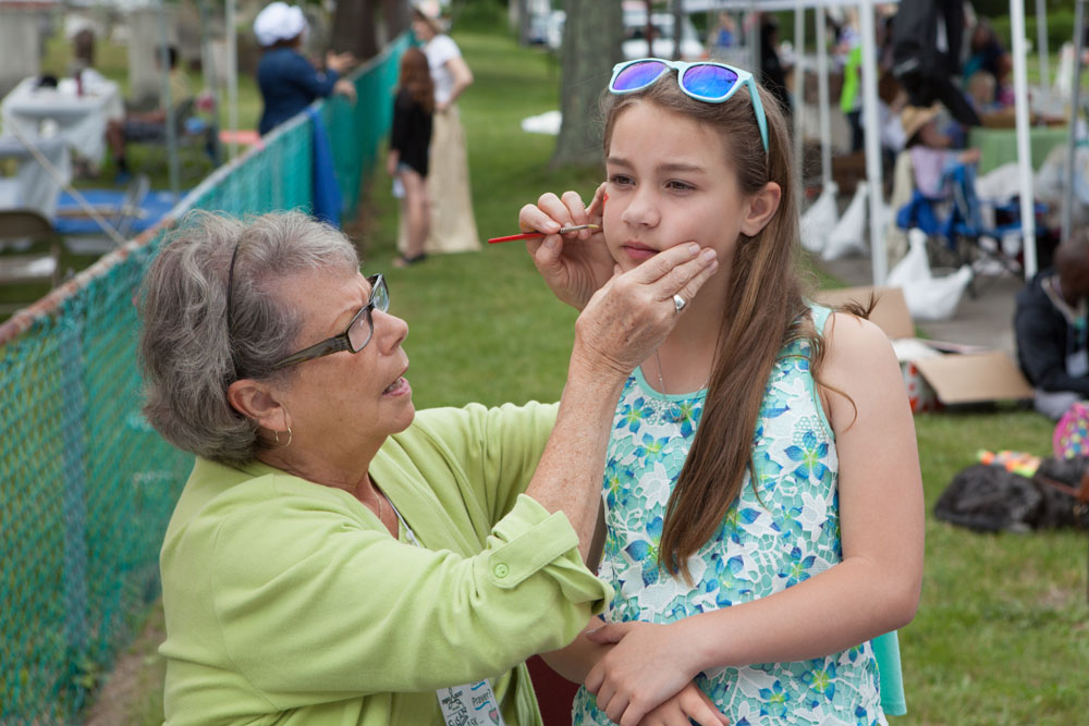 Face painter Susan Brewster works on Annelise Durkin, 10, of Mattituck.