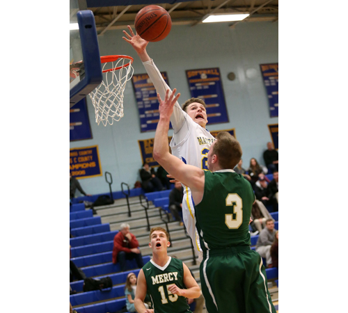 Mattituck's Ryan Mowdy blocking a shot while Bishop McGann-Mercy's Eddie Kneski (15) and Joe Jeskie (3) watch. (Credit: Garret Meade)
