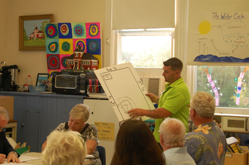 Trevor Johnson shows attendees of the New Suffolk school board meeting plans to renovate the ballfield. (Credit: Nicole Smith)