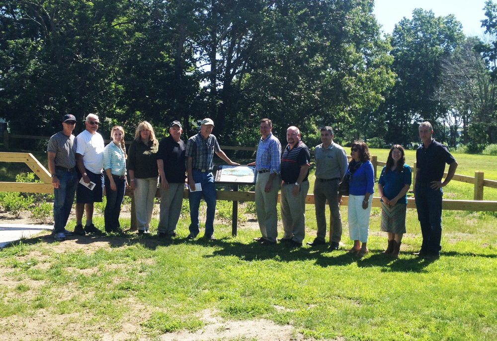 County and town officials met Monday morning to celebrate the completion of the Bay Avenue rain garden. (From left to right) Allan Connell, USDA-NRCS, Peter Young, Town of Southold Conservation Advisory Committee, Sarah Cote, Town of Southold, Sharon Frost, Suffolk County Soil & Water Conservation District, Gerry Goehringer, Mattituck Park District Commissioner, John Bredemeyer, Southold Town Board of Trustees, Al Krupski, Suffolk County Legislator, Jamie Richter, Town of Southold Engineer, Michael Collins, Town of Southold Civil Engineer, Elizabeth Condon, Suffolk County Soil & Water Conservation District, Polly Weigand, Suffolk County Soil and Water Conservation District, and Jeff Standish, Town of Southold Public Works. (Credit: Courtesy)