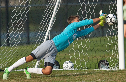 GARRET MEADE PHOTO | Shoreham-Wading River goalkeeper Adam Piotrowski pushing aside a penalty kick by Southold's Will Richter.