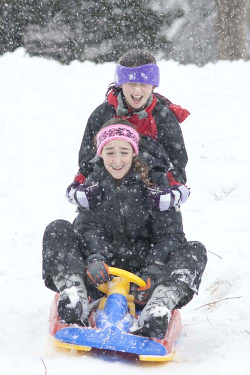 KATHARINE SCHROEDER PHOTO | Twelve-year-old Katie Parks of Cutchogue hangs on to Madelyn Shannon, 12, also of Cutchogue at the sledding hill in Mattituck.