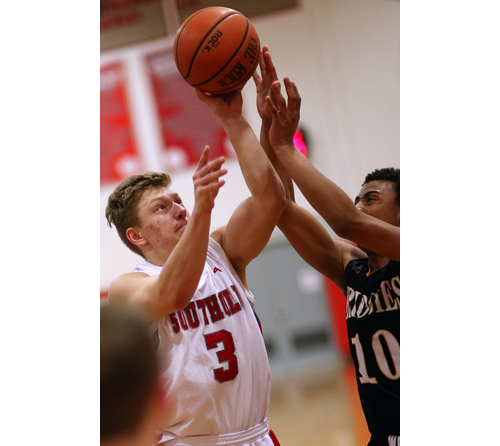 Pat Mejsak, who scored 10 points for Southold, is challenged by Bridgehampton's Tylik Furman while attempting a shot. (Credit: Garret Meade)