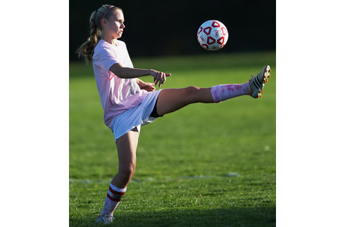 Southold/Greenport's goal scorer, Megan Van Bourgondien, lifting her leg high in the air in an attempt to control the ball. (Credit: Garret Meade)