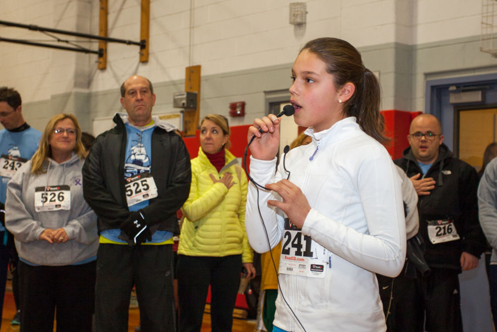 Southold 6th grader Juliet Rand sings the Star Spangled Banner before the race.