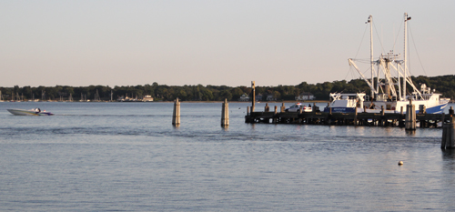 Passegers of this cigarette boat (left) were ejected into Greenport Harbor on Monday. (Credit: Jen Nuzzo)