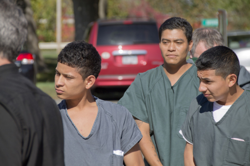 Southold shooting suspects (from left) Walter Vasquez, 17, of Greenport; Pedro Emilio Santamaria, 31, of Greenport; and Jeremias Nathaniel Recinos Torres, 19, of Aquebogue are escorted by corrections officers into Southold Town Court earlier this year. (Credit: Paul Squire, file)