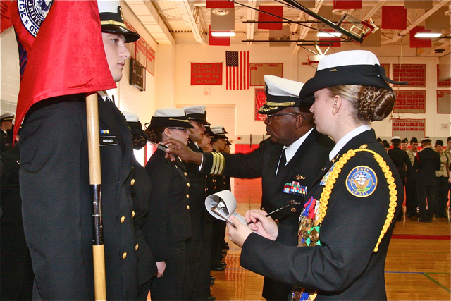 Commander Jimmie Miller with Lt. Julie Dickerson measures everything on the uniform as Lt. Dickerson records it.
