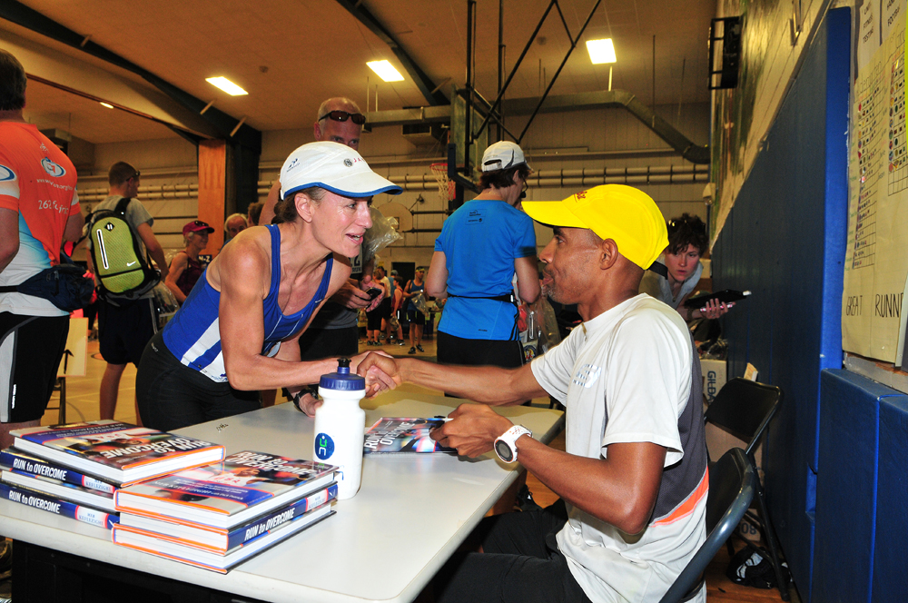 Boston Marathon winner Meb Keflezighi autographs copies of his book prior to the race. (Credit: Bill Landon)