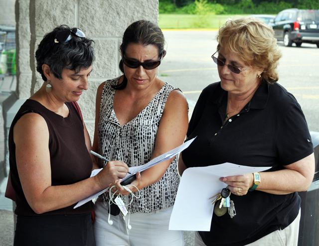 Southold Town trustee candidate Abigail Field, left, of Cutchogue signs a petition to create the Women's Equality Party line. The petition was being circulated by a group of fellow Democrats at the King Kullen in Cutchogue Sunday, including Jennifer Maertz of Rocky Point, center, and local committeewoman Lynn Summers of Southold.