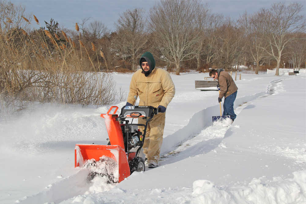Craig Owens of Greenport and Michael Bredemeyer of Orient tackle snowed in walkways so patrons could gain access to the park.