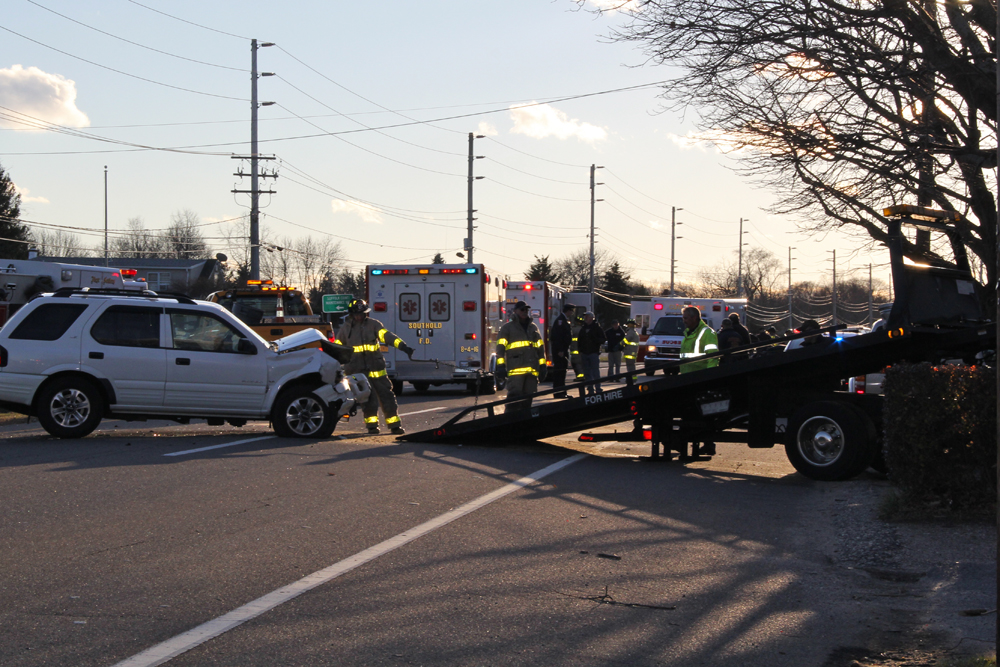 Fire department volunteers helping to clear the damaged vehicle. (Credit: Carrie Miller)